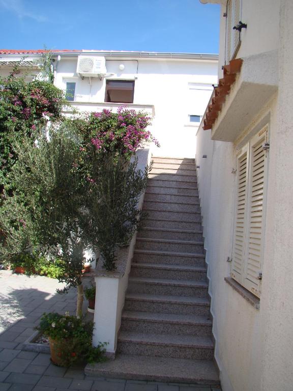 a staircase leading up to a building with pink flowers at Apartment Tičić in Povljana