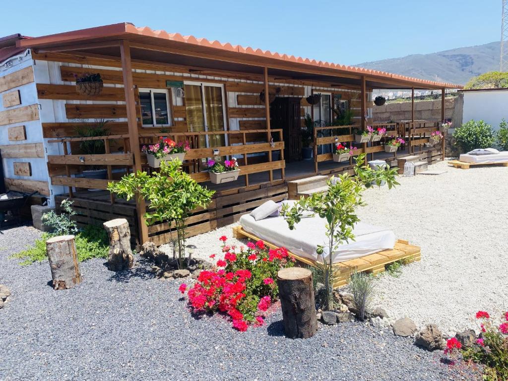 Cabo BlancoにあるBernegal Maday, Heated Bathtub Piscina y Jardin by Deihu Experiencesのベッドと花が目の前にある家