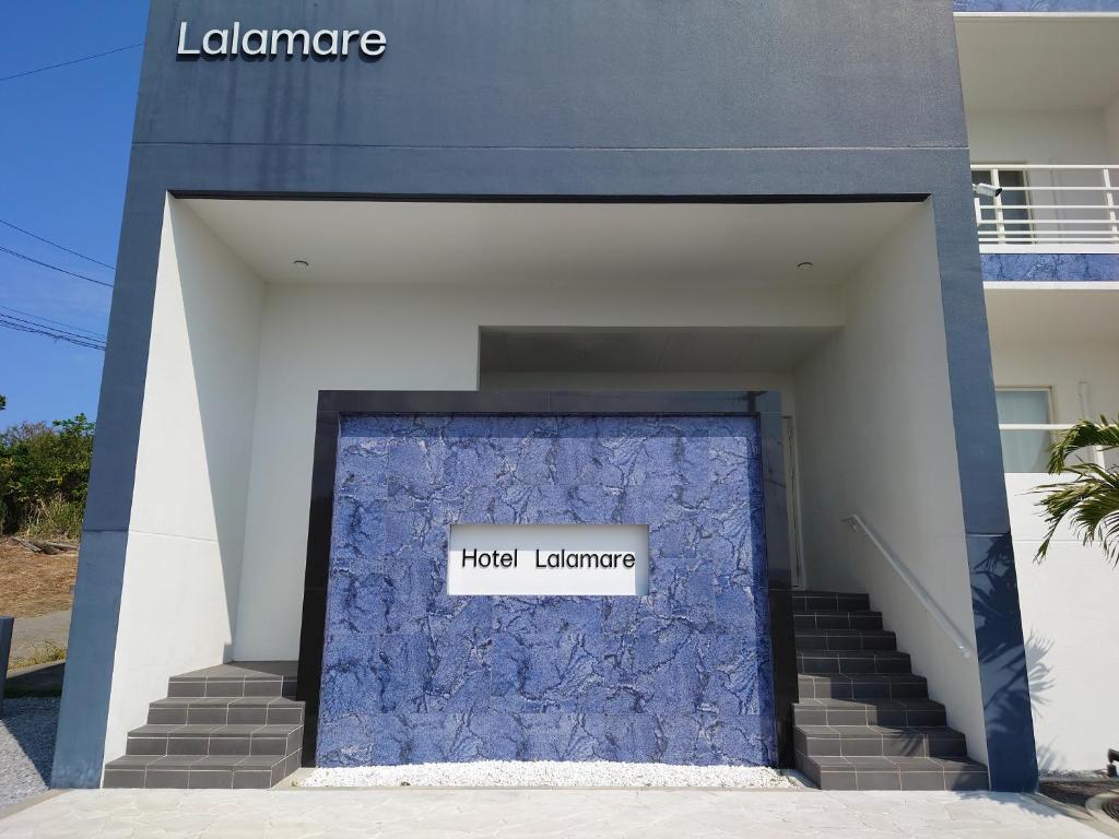 今歸仁的住宿－Lalamare Kouri，一座建筑,上面有蓝色的门,上面有标志