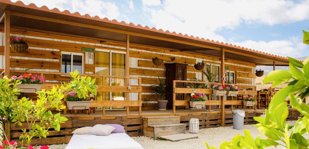 a wooden house with benches and potted plants at Bernegal Moneyba, Hot Tub, Piscina y Jardín in Buzanada