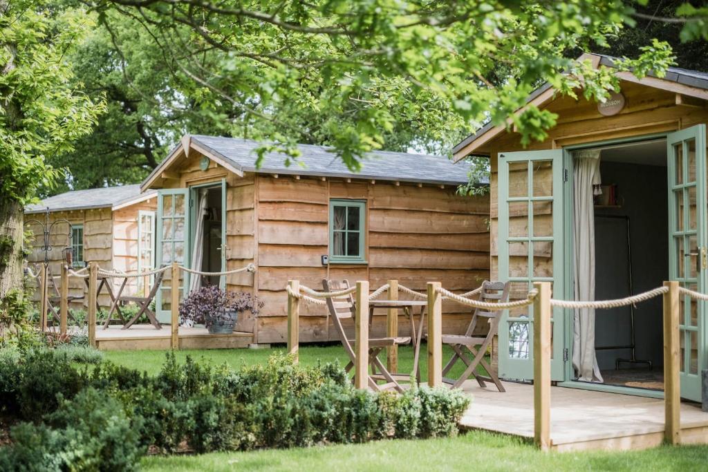 Domek z werandą, stołem i krzesłami w obiekcie Toad Hall Lodges - Luxury Eco Lodges Near Southwold! w mieście Wangford