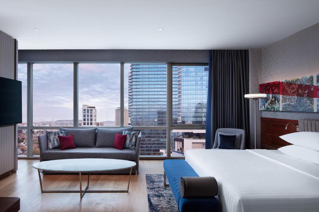 Pokój hotelowy z dużym łóżkiem i kanapą w obiekcie Delta Hotels by Marriott Istanbul Levent w Stambule