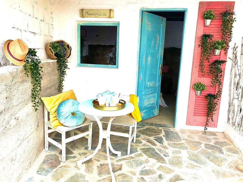 una mesa y dos sillas frente a una puerta en Macaronesia Love Spa, sauna y piscina en Buzanada