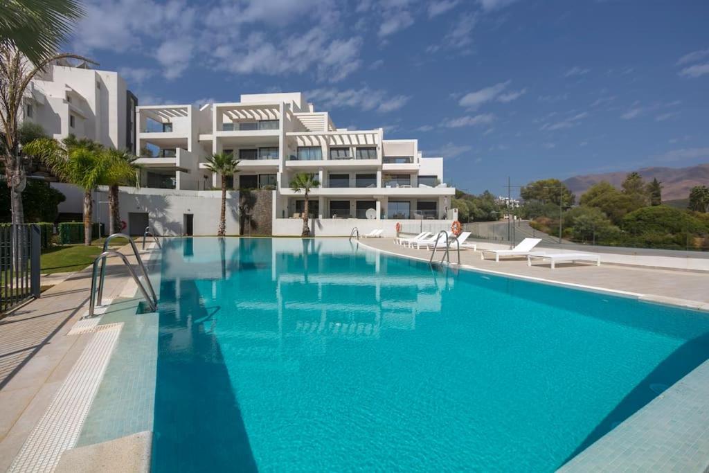 una gran piscina frente a un edificio blanco en Luxury 2bed apartment Mirador del Golf, Estepona, en Estepona