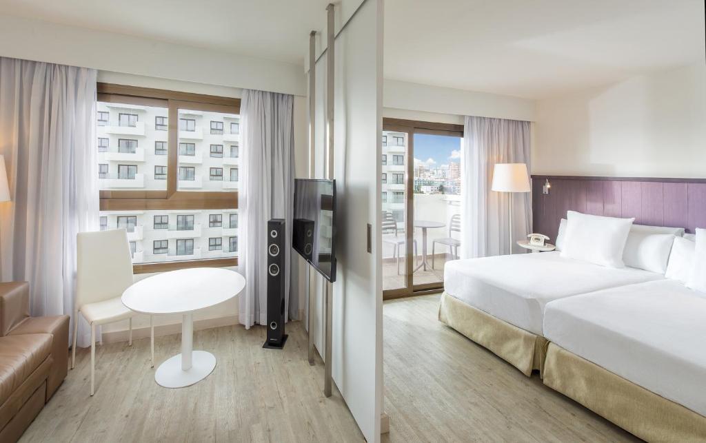 a hotel room with a bed and a desk and a window at Hotel Ocean House Costa del Sol, Affiliated by Meliá in Torremolinos