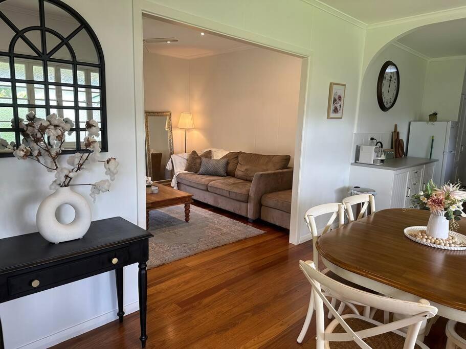 uma sala de estar com uma mesa e um sofá em Cosy Queenslander in the heart of town. em Mareeba