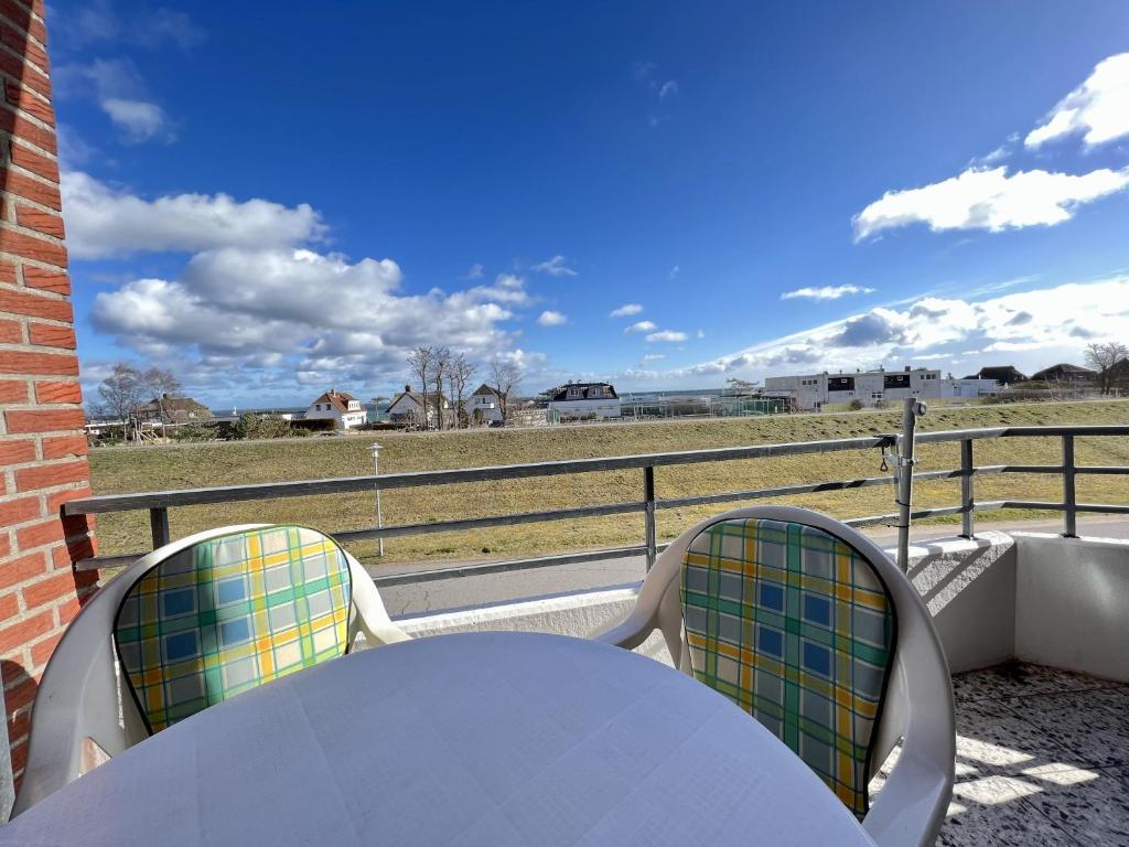 a table and chairs with a view of a field at Haus am Deich Wohnung 10 in Dahme