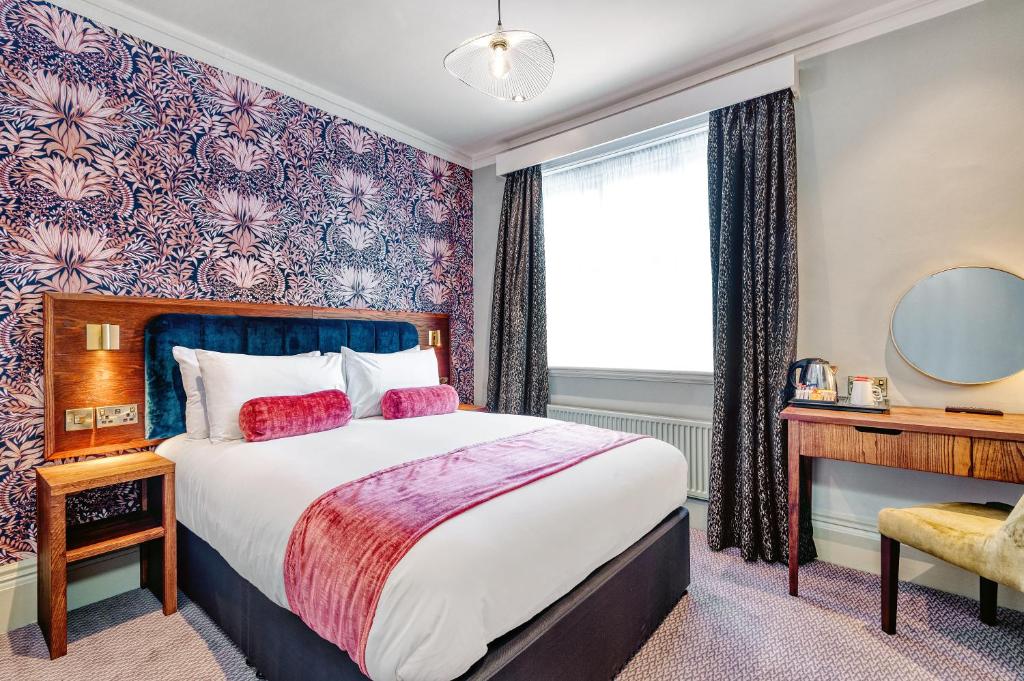 a bedroom with a bed and a desk and a window at The Hand & Sceptre by Innkeeper's Collection in Southborough