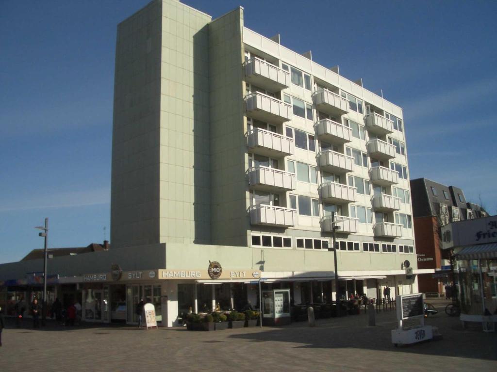 un gran edificio en una ciudad con gente delante en Studioappartement Wegg Wilhelmstraße en Westerland