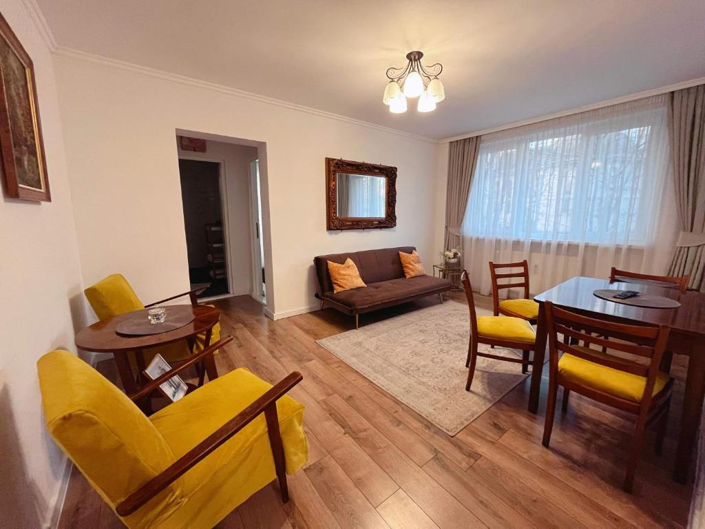 a living room with a table and chairs and a couch at Niran Apartament in Oradea