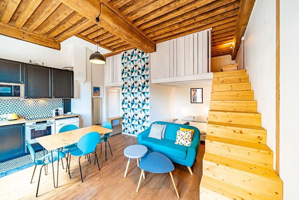 里昂的住宿－Superb 1 bedroom apartment - Croix Rousse district，厨房以及带蓝色沙发和桌子的客厅。