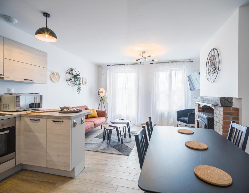 a kitchen and dining room with a table and a kitchen and a living room at Les Duplex du Lac d'Orient in Mesnil-Saint-Père