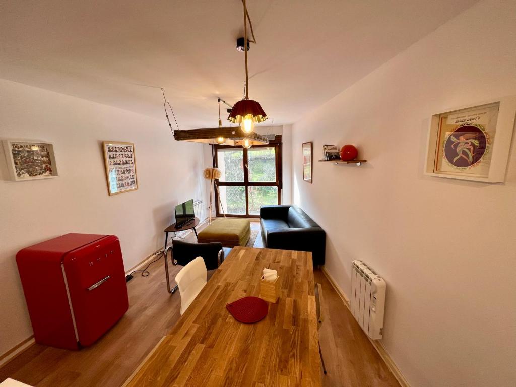 un soggiorno con tavolo e frigorifero rosso di Loft Fuentes a Felechosa