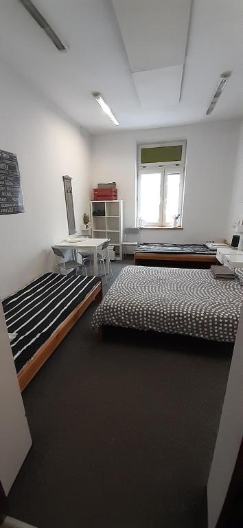 Habitación con 2 camas, mesa y ventana en Master Corner Apartment, en Cracovia