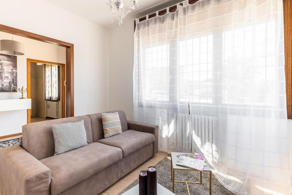 - un salon avec un canapé et une grande fenêtre dans l'établissement “Casa Moderna con parcheggio privato”, à Imola