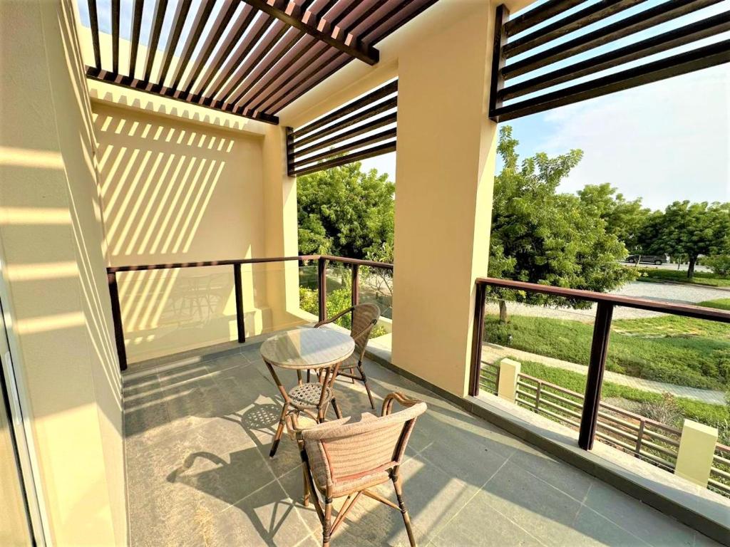 un patio con 2 sillas y una mesa en el balcón en Luxurious 3B Villa with Balcony in Ras Al Khaimah, en Ras al Khaimah