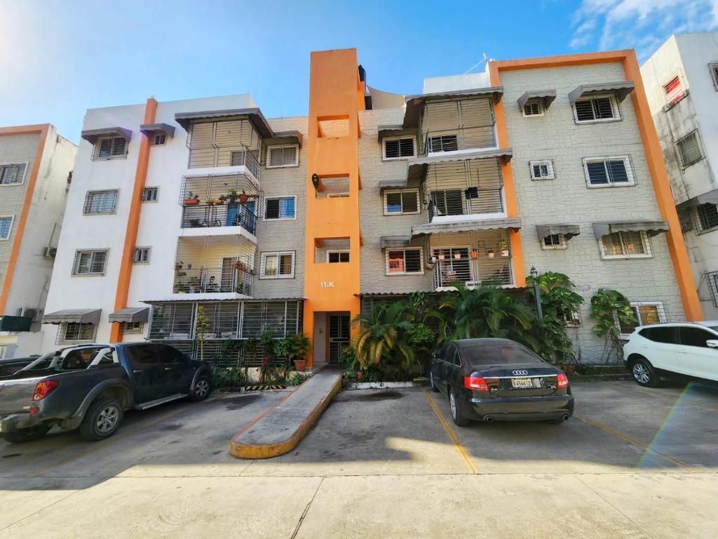 un gran edificio de apartamentos con coches aparcados en un aparcamiento en ESPACIO TRANQUILO en Cabayona