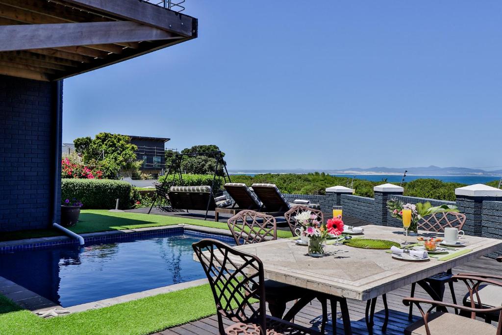 a patio with a table and chairs next to a pool at The Whale's Tale Guesthouse in Hermanus