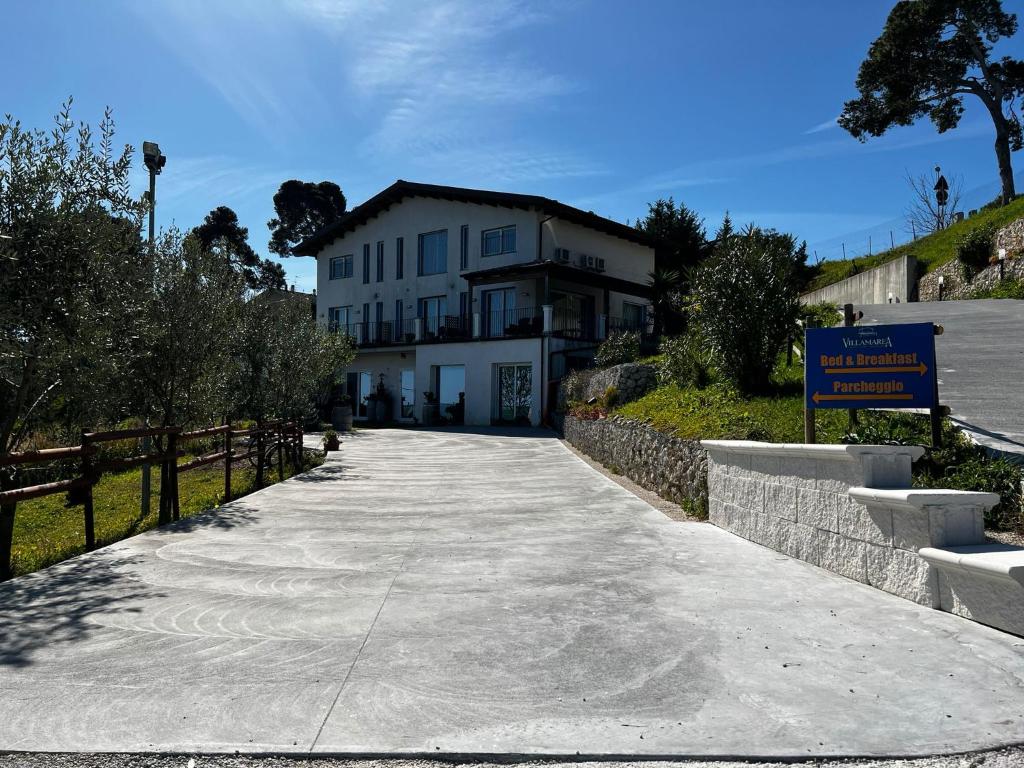 un bâtiment blanc avec un panneau à côté d'un trottoir dans l'établissement B&B Villamarea, à Francavilla al Mare