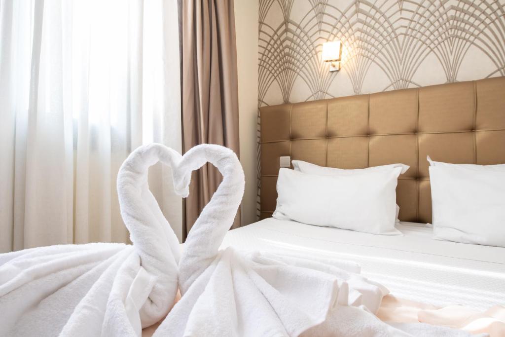 Dos cisnes en una cama en una habitación de hotel en Athens Golden City Hotel en Athens