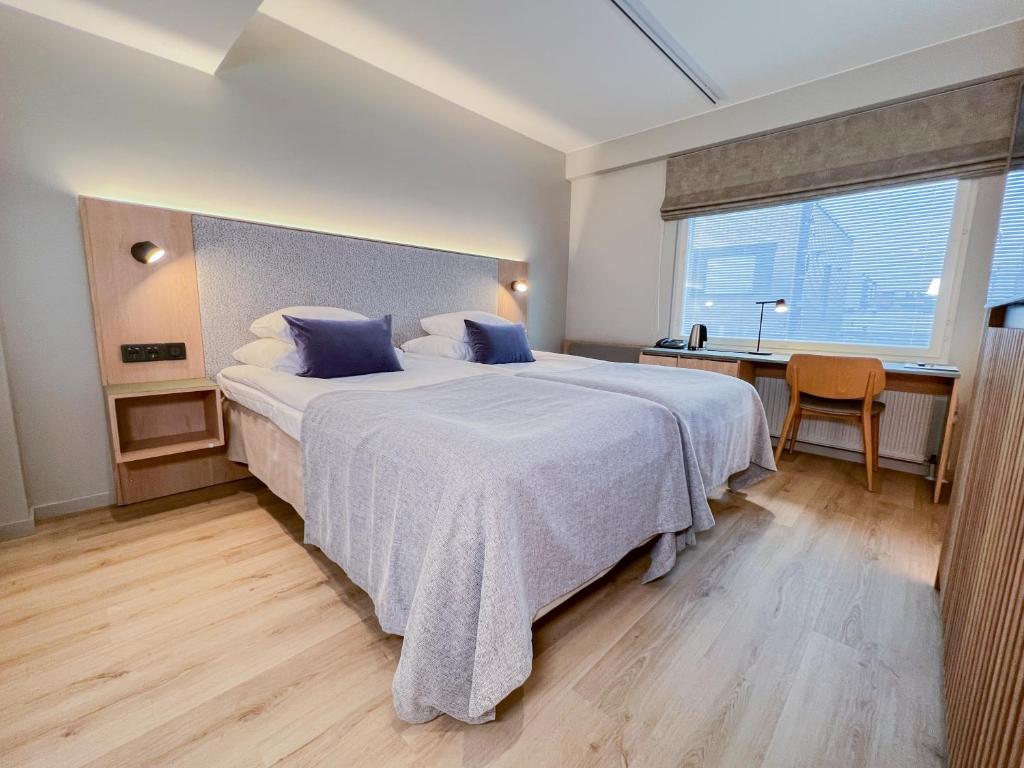 1 dormitorio con 1 cama grande con almohadas azules en Original Sokos Hotel Valjus Kajaani en Kajaani