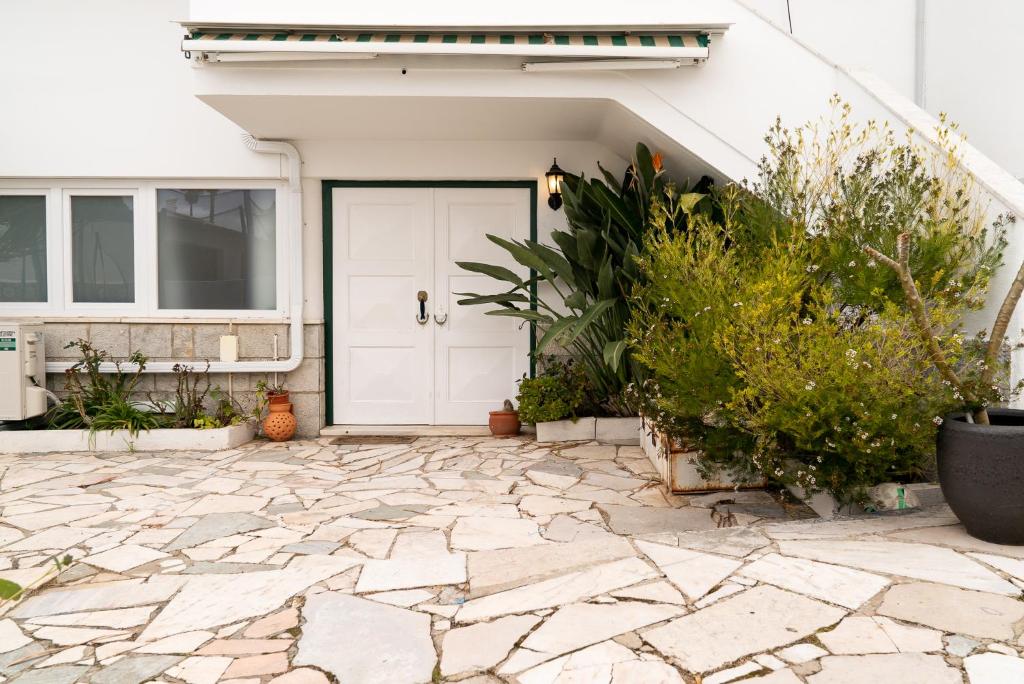 a front door of a house with a stone patio at 2 Bedroom Apartment House - Sol do Murtal in Parede