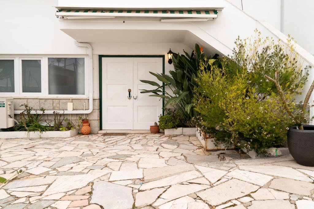 uma porta da frente de uma casa com um pátio de pedra em 2 Bedroom Apartment House - Sol do Murtal em Parede