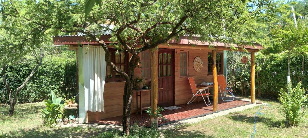 eine kleine Holzhütte mit einem Tisch im Garten in der Unterkunft Monoambiente Elegante in Los Hornillos