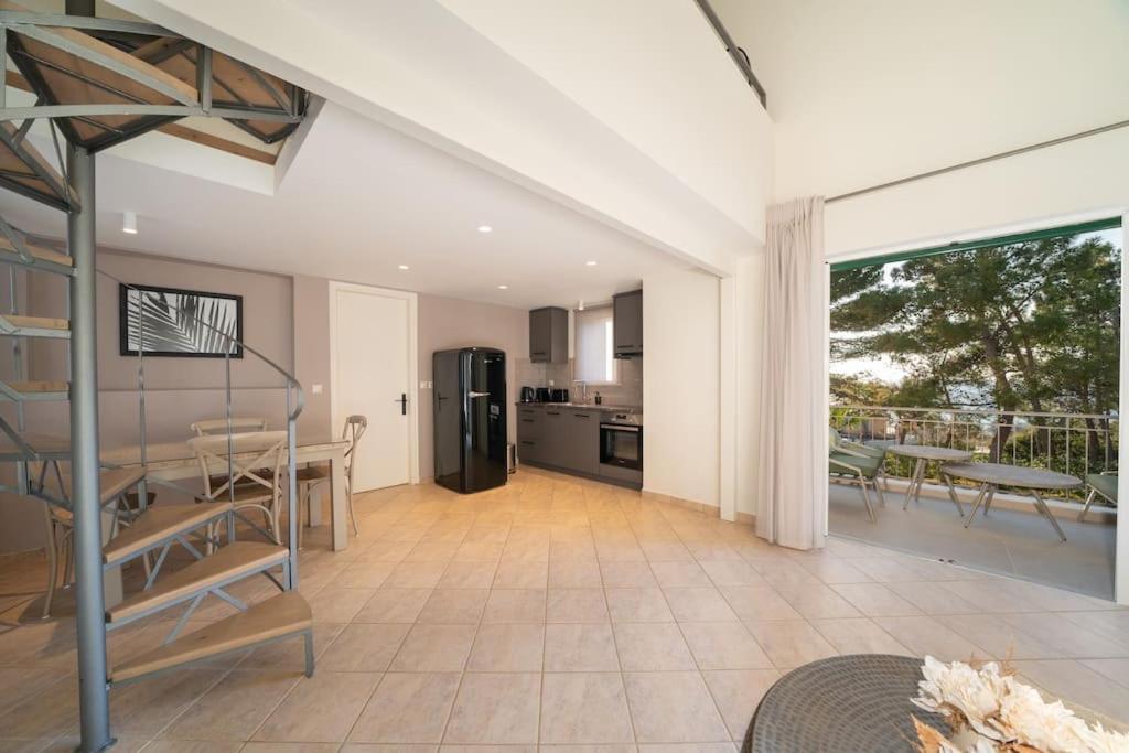 een keuken en een woonkamer met een tafel en stoelen bij Seashell Luxury Residence - Apartment 2 in Lixouri