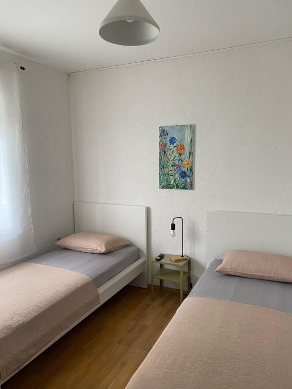 una camera con due letti e un dipinto sul muro di Apartment M & M a Spalato (Split)
