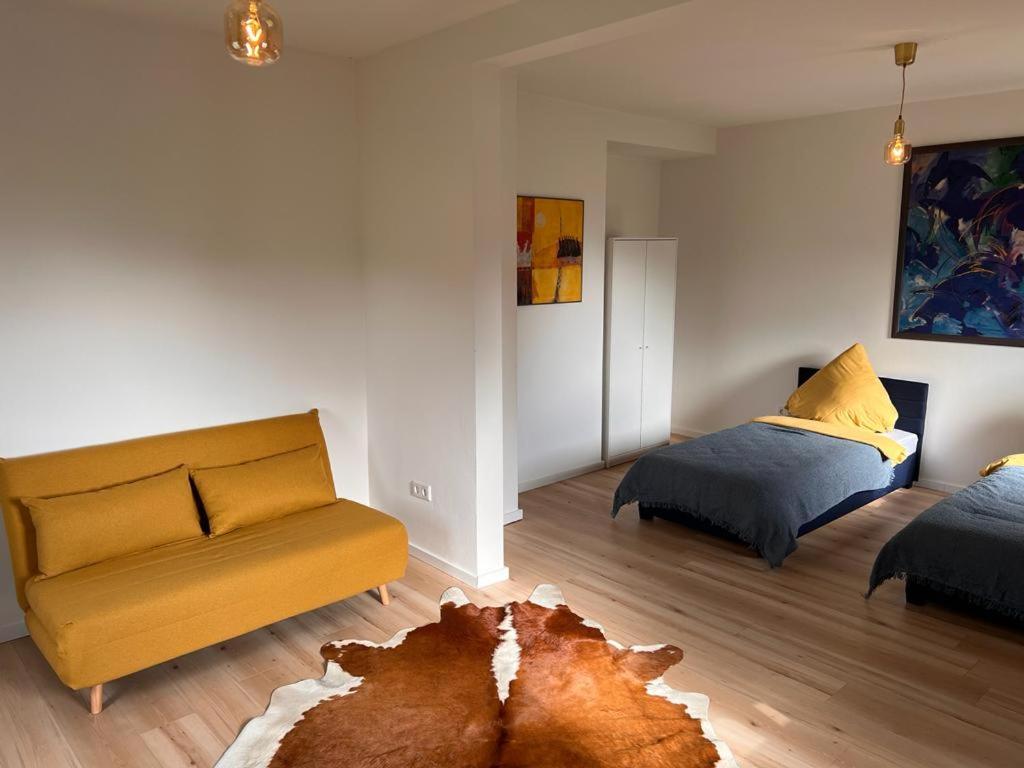 ein Wohnzimmer mit einem Sofa und einem Bett in der Unterkunft Rust-Appartements-II-Marienrode in Hildesheim