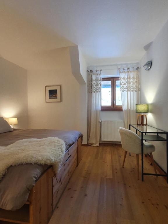 a bedroom with a bed and a table and a window at Refuge Hôtel de Bayasse in Uvernet