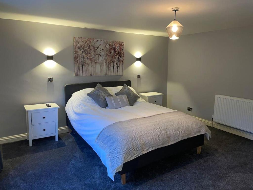 - une chambre avec un grand lit et une peinture murale dans l'établissement Immaculate 2-Bed Apartment above Village Pub, à Buxton