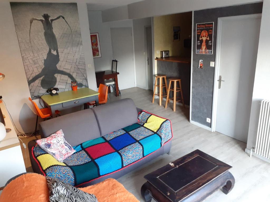 ein Wohnzimmer mit einem Sofa und einem Tisch in der Unterkunft Appartement centre-ville Rennes in Rennes