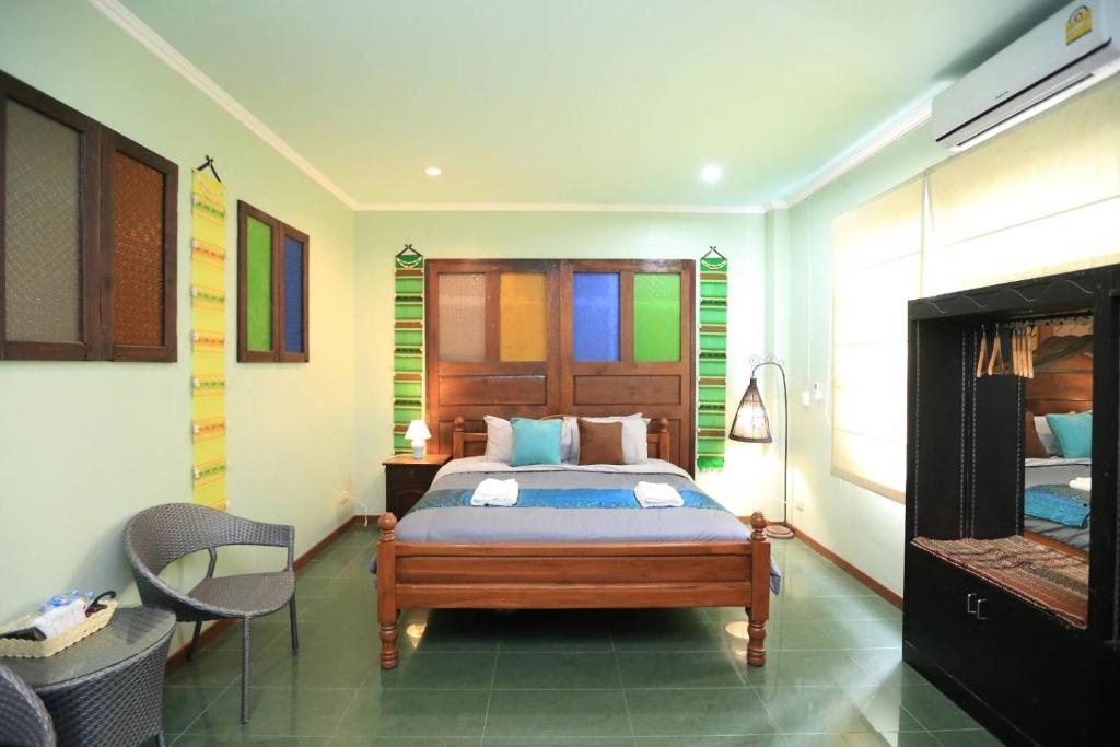 1 dormitorio con 1 cama y 1 silla en นอนในสวน รีสอร์ท en Bangkok