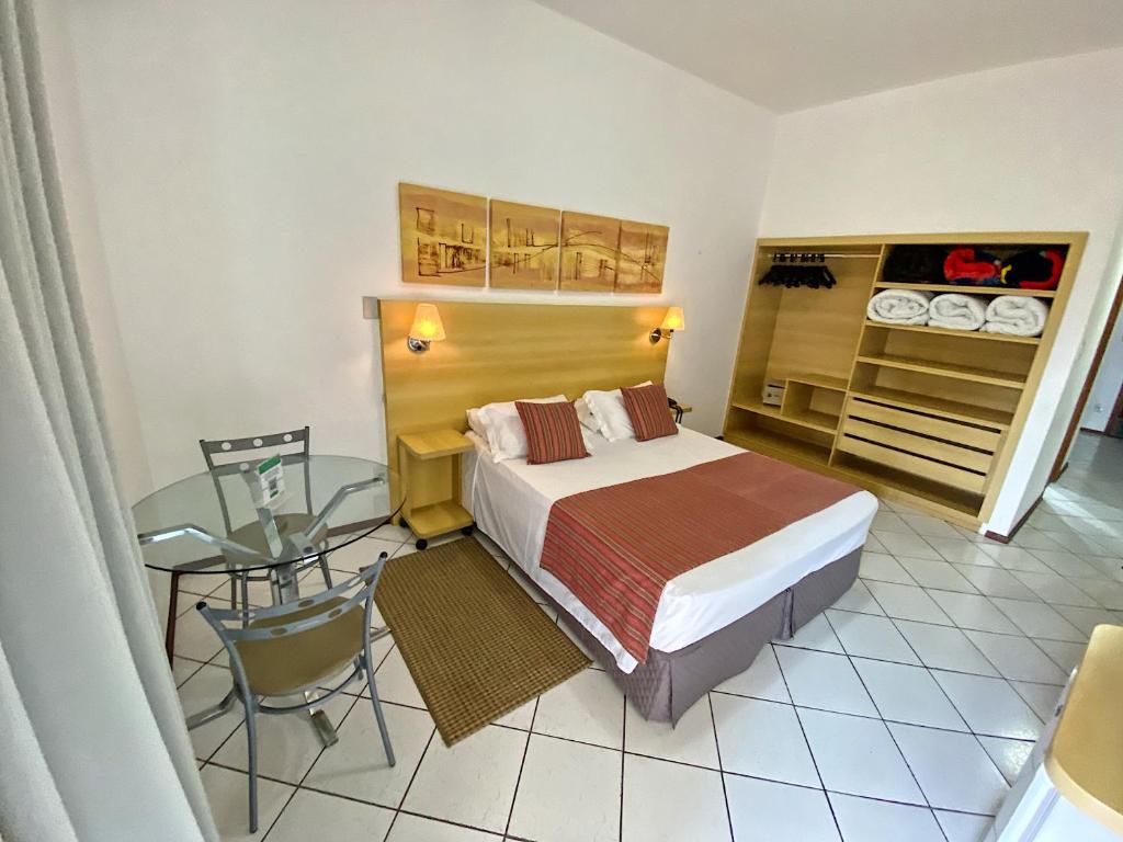 a bedroom with a bed and a glass table at Hotel Cabreúva Resort in Cabreúva