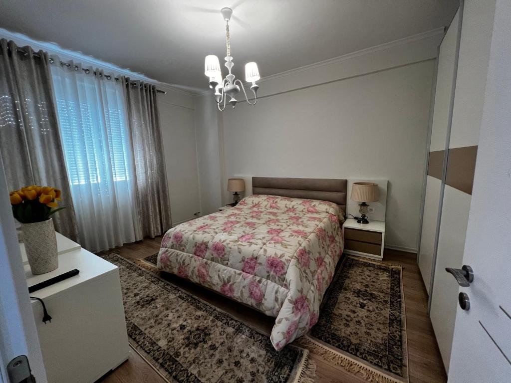 um quarto com uma cama e um lustre em Noa's happy place em Tirana
