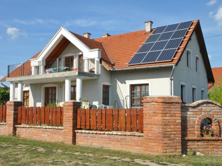 una casa con paneles solares en el techo en Hóvirág Vendégház, en Balatonakali