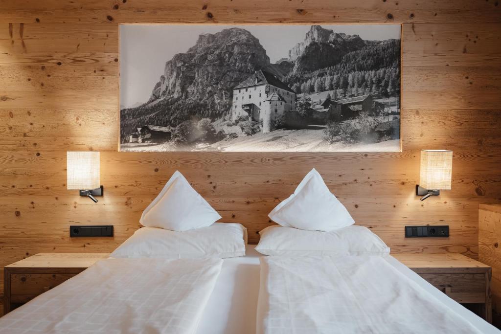 a bedroom with two beds and a picture on the wall at Gourmet Hotel Gran Ander in Badia