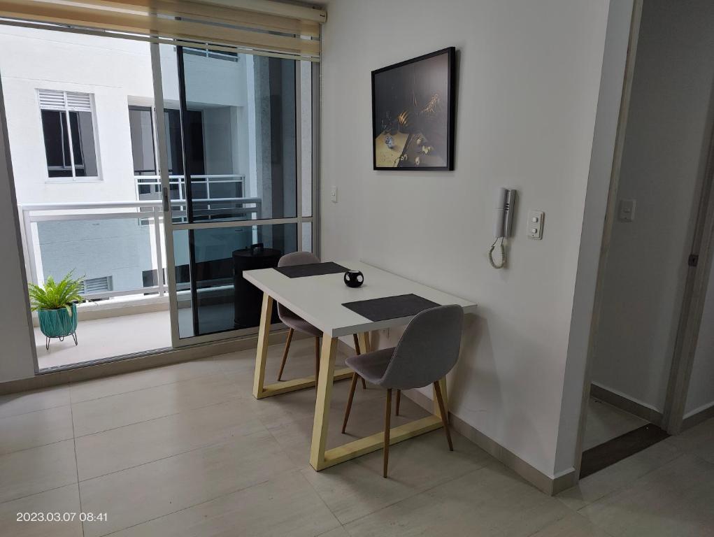 mesa y sillas en una habitación con ventana en Apartamento en el norte con parqueadero y vista, en Armenia