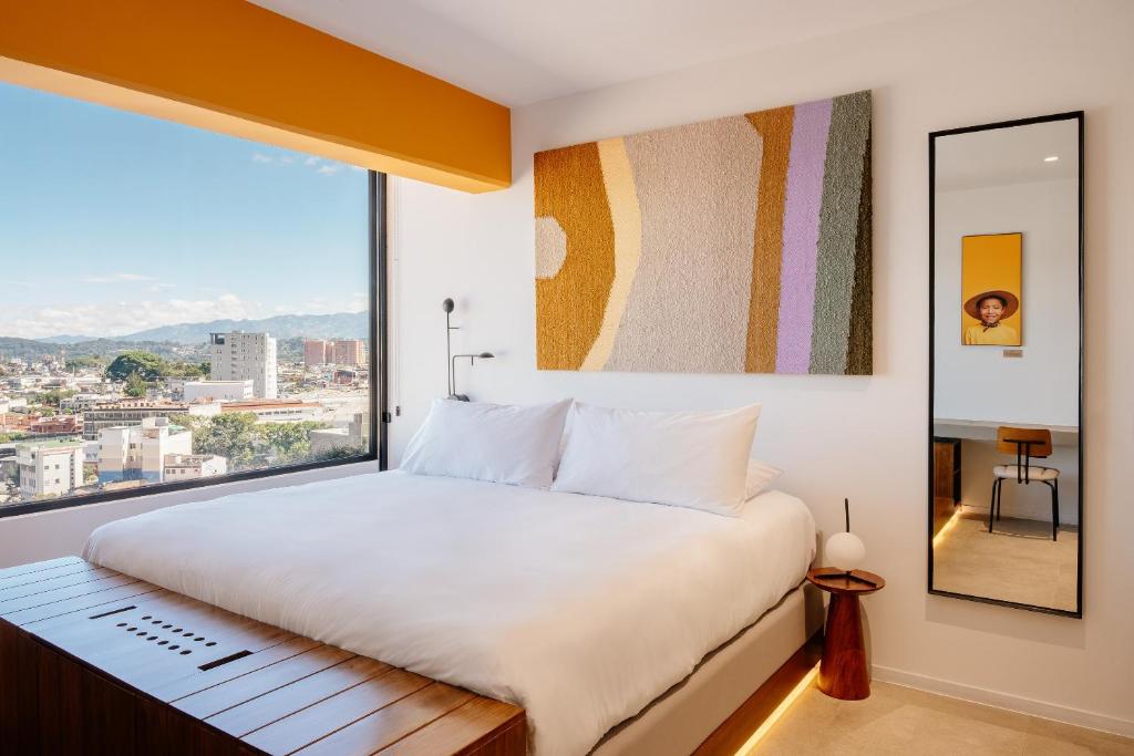 a bedroom with a large bed and a large window at Good Hotel Guatemala City in Guatemala