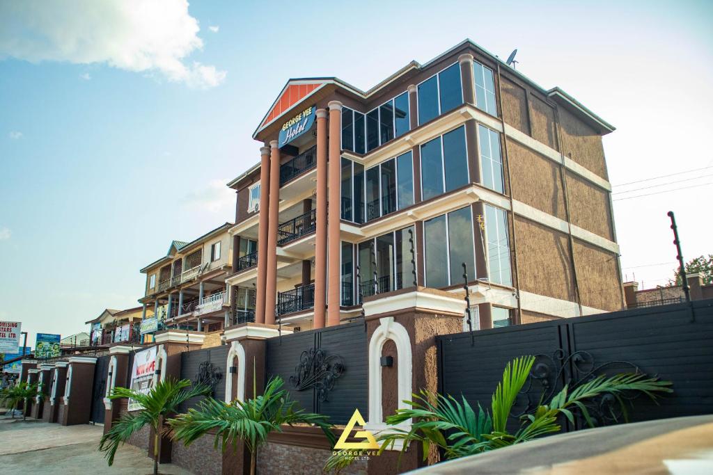 a tall building with glass windows on a street at GEORGE VEE HOTEL LTD in Kumasi