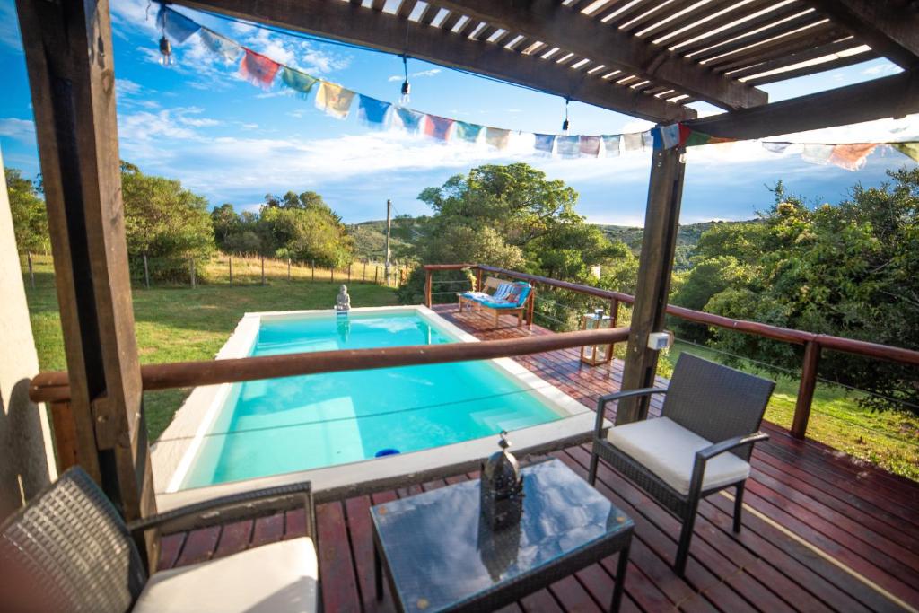 una terrazza con piscina, tavolo e sedie di Marrakech Villa Serrana a Villa Serrana