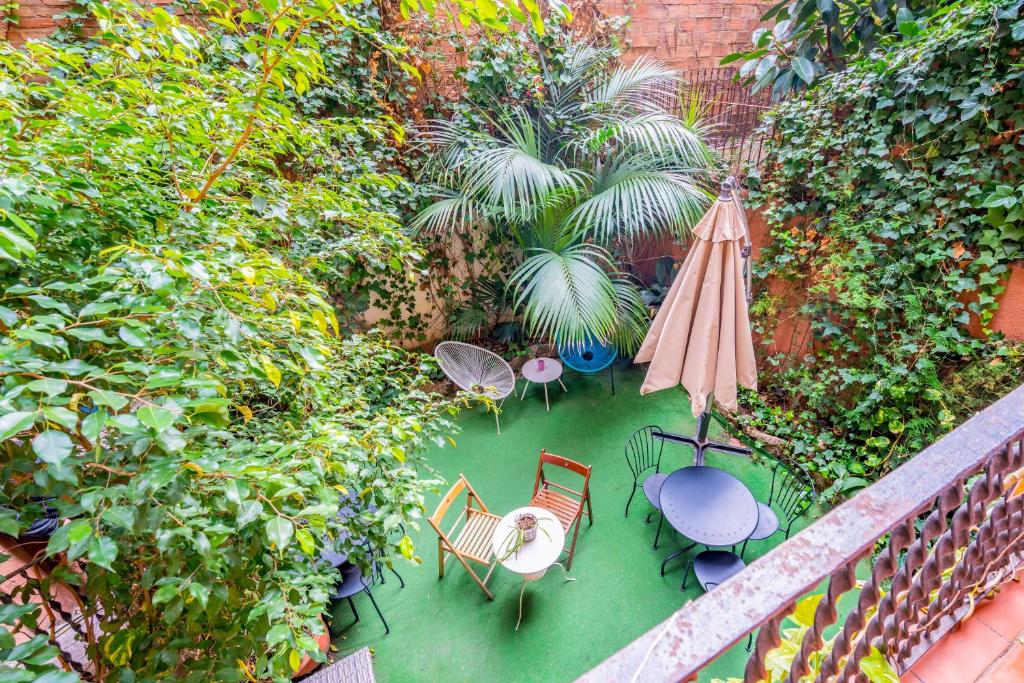 an overhead view of a patio with chairs and an umbrella at Casa Barcelo Hostel Barcelona in Barcelona