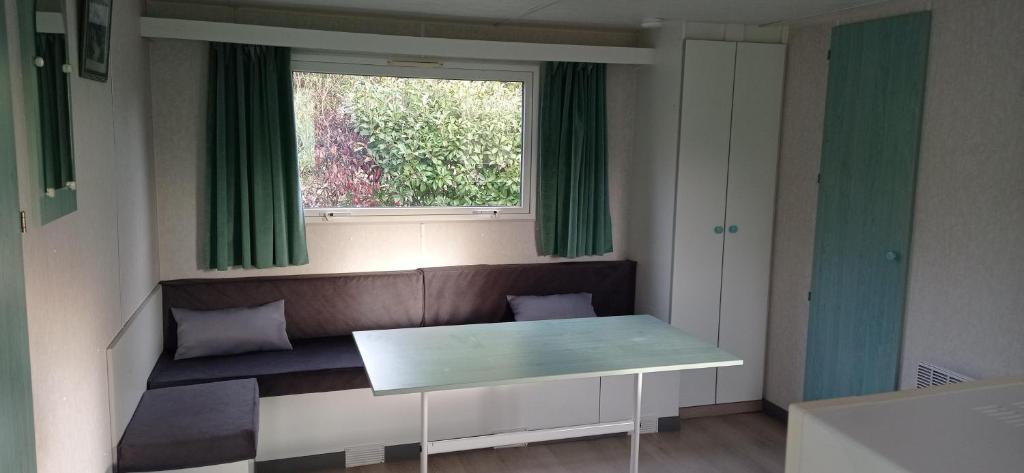 a small room with a bench and a window at CAMPING LE BEL AIR mobil home LE PALMIER 4 personnes in Limogne-en-Quercy
