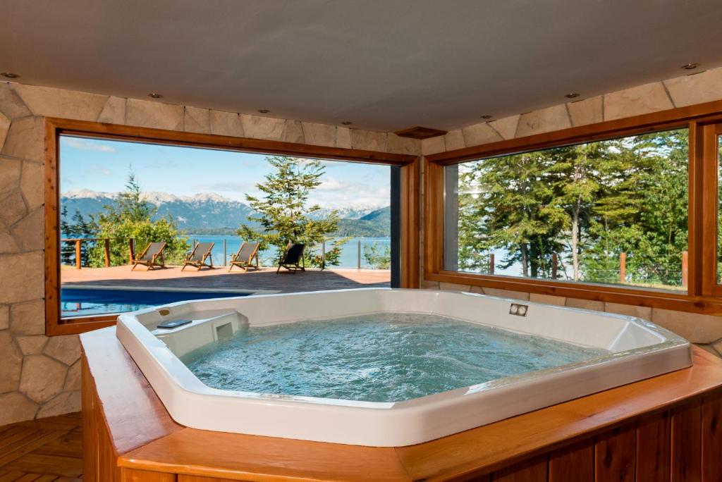 a large tub in a room with a large window at Hosteria La Camila in Villa La Angostura