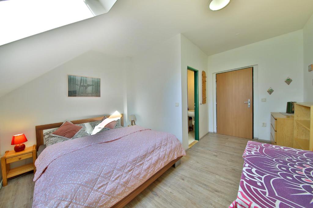 a bedroom with a large bed with a purple comforter at Penzion Kairos in Klokočí