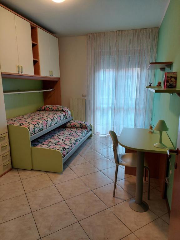 a room with two beds and a table in it at La Conchiglia in Porto SantʼElpidio