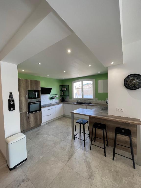 eine große Küche mit einem Holztisch und Stühlen in der Unterkunft Villa Andrée avec piscine à proximité de la mer in Saint-Cyr-sur-Mer