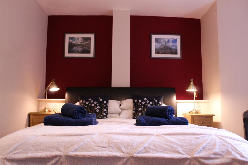 a bedroom with a large bed with blue pillows on it at Acomb Lodge in Harrogate